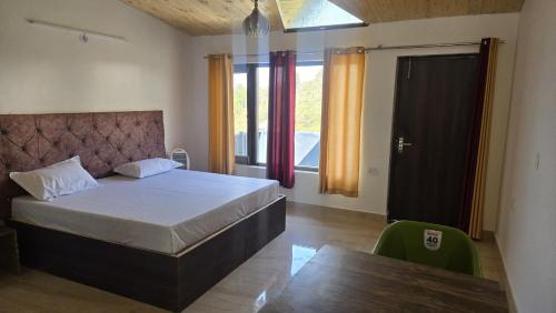 a bedroom with a bed and a large window at Shanti Residency Ramgarh in Rāmgarh