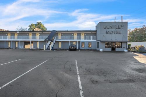 an empty parking lot in front of a motel at Bentley Motel in Linden