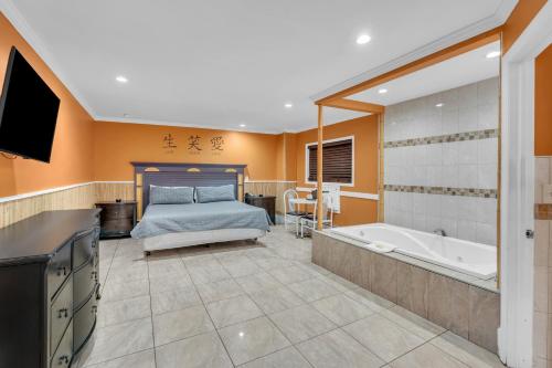 a bedroom with a bed and a tub and a television at Bentley Motel in Linden