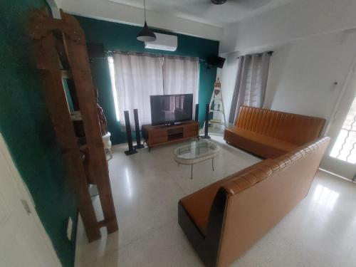 Una sala de estar con un sofá y un televisor. en A Borneo Guesthouse, en Johor Bahru