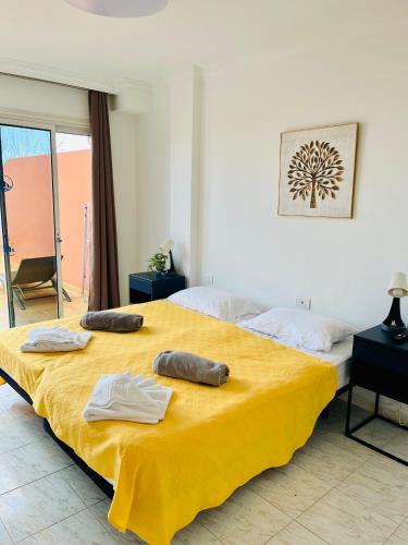 a bedroom with two beds with towels on a yellow blanket at Cielo Dorado in Santiago del Teide