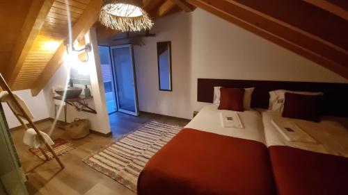 una camera da letto con un letto grande con cuscini rossi di Eco Charm Discovery Quinta da Oliveirinha a Helenos