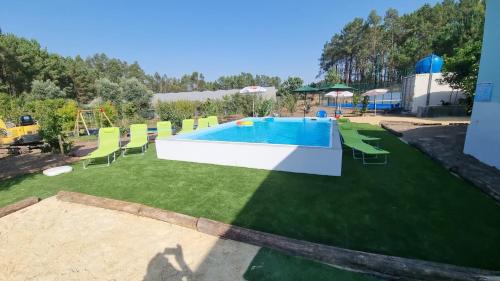 a backyard with a swimming pool and green grass at Eco Charm Discovery Quinta da Oliveirinha in Helenos