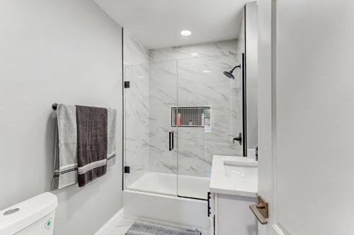 Un baño blanco con ducha y lavabo. en MC Beach Getaway, en Pottawattamie Park