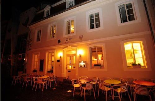a group of tables and chairs in front of a building at Hotel Fuchs Saarbrücken in Saarbrücken