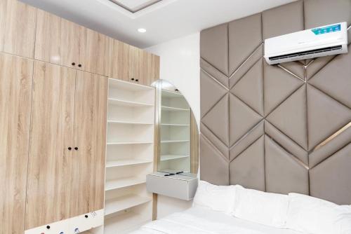 a bedroom with a bed and a wall with shelves at Luxury 3BR Apt w balcony view in Chevron, Lekki in Lekki