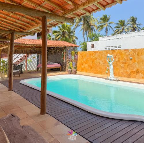 a swimming pool in a backyard with a wooden deck at Pousada Recanto dos Ventos in Icaraí