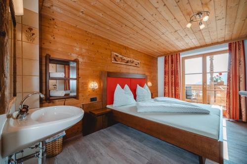 ein Schlafzimmer mit einem Bett, einer Badewanne und einem Waschbecken in der Unterkunft Ferienhaus Scheiber in Leogang