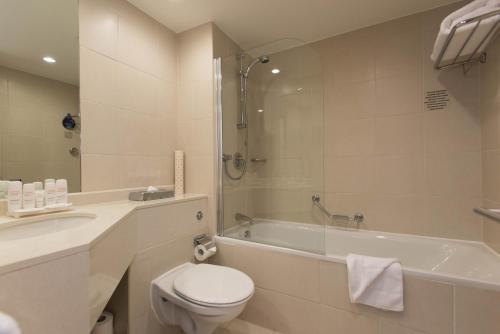 a bathroom with a toilet and a tub and a sink at Radisson Blu Waterfront Hotel, Jersey in Saint Helier Jersey