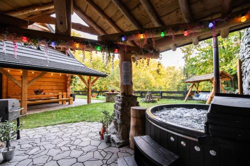 un patio avec un jacuzzi et un pavillon en bois dans l'établissement Chata na Skarpie - SPA i widok na Skrzyczne, à Szczyrk