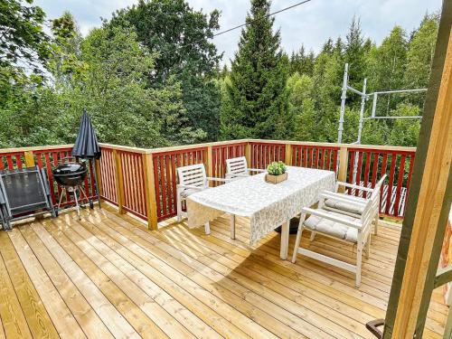 a wooden deck with a table and chairs and a grill at 5 person holiday home in HÄRADSBÄCK-By Traum in Ryd