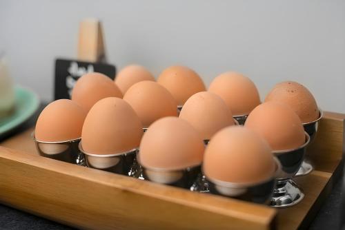 a bunch of brown eggs in mufflers in a tray at The Chapter Hotels - London Hyde Park in London