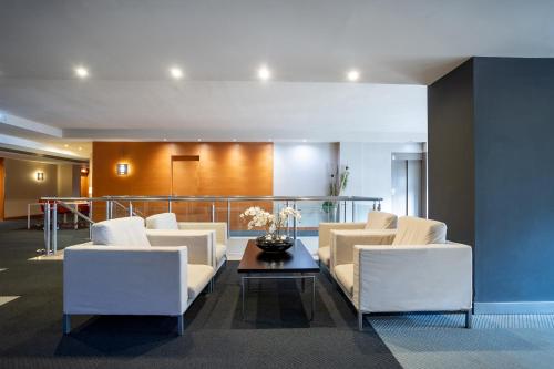 a lobby with white chairs and a table at Eurostars Atlántida in Santa Cruz de Tenerife