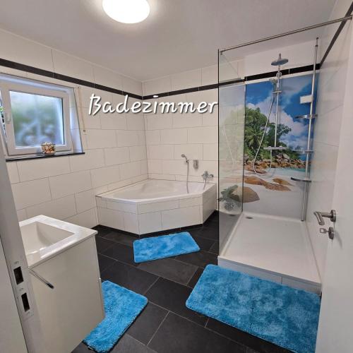 バート・ヘレンアルプにあるFerienwohnung Burkhardtのバスルーム(バスタブ、青いラグ付きのシャワー付)