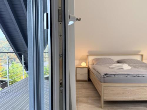 a bedroom with a bed next to a balcony at Ferienhaus Sonnenblick in Heringhausen