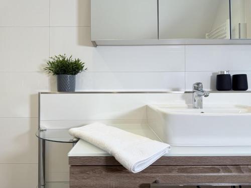 a white bathroom with a sink and a mirror at Ferienhaus Sonnenblick in Heringhausen