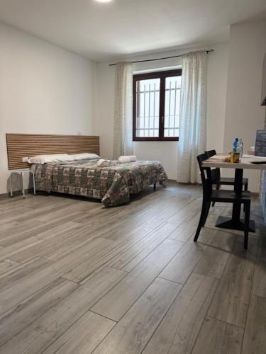 a bedroom with a bed and a desk and a table at La Maison di Vicolo Torre in Uboldo