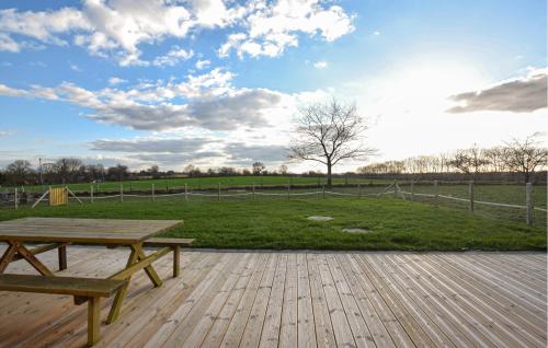 a wooden deck with a picnic table and a field at Awesome Home In Bacilly With Wifi in Bacilly