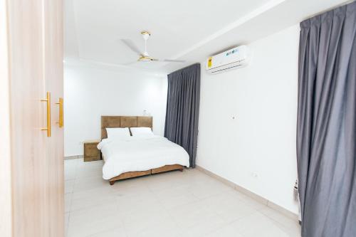 a small bedroom with a bed and a window at Luxurious townhouse behind Achimota Mall in Accra