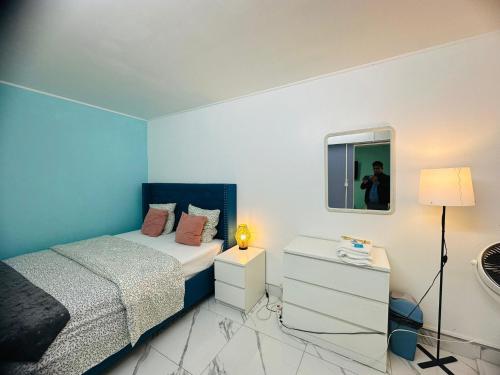 Un dormitorio pequeño con una cama y un espejo. en Holiday Apartment 01, en Aubervilliers