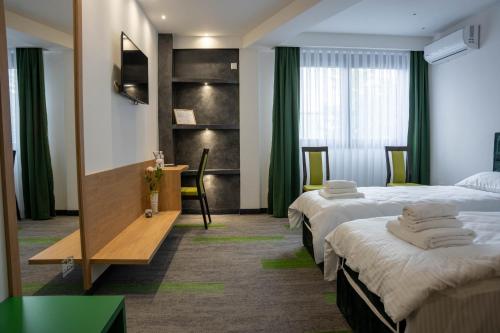 een hotelkamer met twee bedden en een bureau bij Motel Brist in Zenica