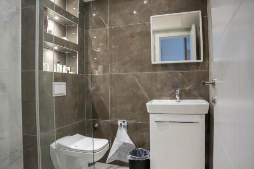 een badkamer met een toilet, een wastafel en een spiegel bij Motel Brist in Zenica