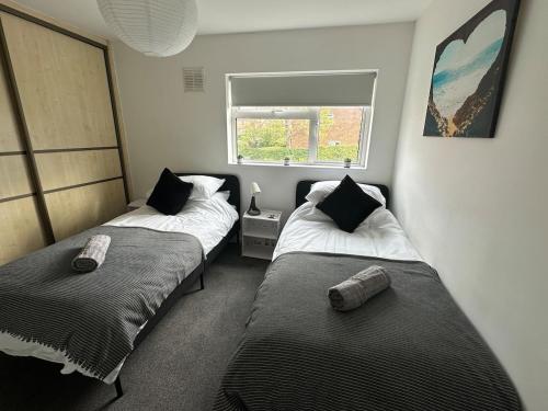 two beds in a small room with a window at 3 bedroom house, stones throw from SMH in Bristol