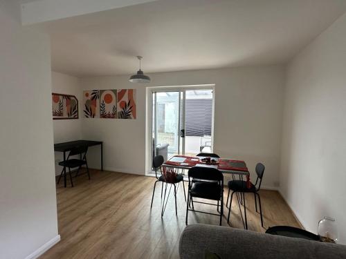 a living room with a table and chairs at 3 bedroom house, stones throw from SMH in Bristol