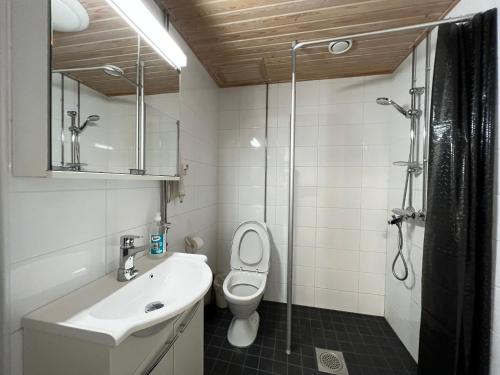 a bathroom with a toilet and a sink and a shower at Cozy flat in Suurpelto in Espoo