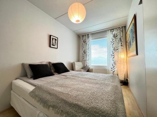 a bedroom with a large bed with a window at Cozy flat in Suurpelto in Espoo