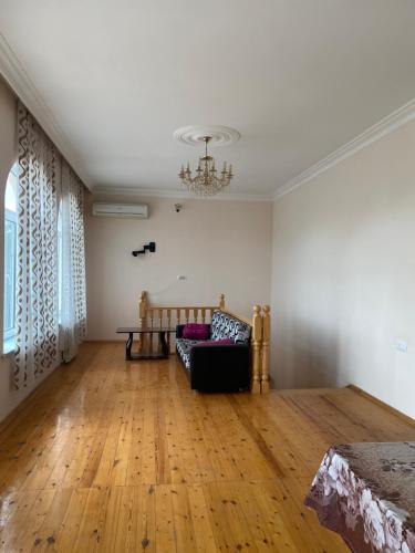 Una sala de estar con un sofá y suelo de madera. en Baku Garden House, en Baku