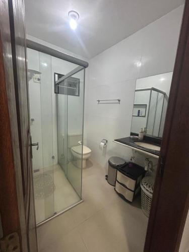 a bathroom with a glass shower and a toilet at Casa Confortável in Belém