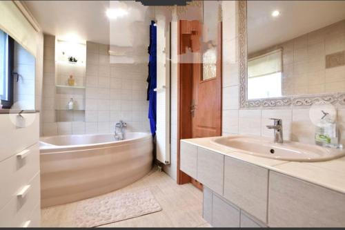 a bathroom with a tub and a sink at BIZAR Hostel in Sadowa