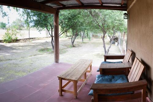 a porch with two wooden benches and a table at Cabañas Mi Cata Hermosa - Catamarca Capital in San Fernando del Valle de Catamarca
