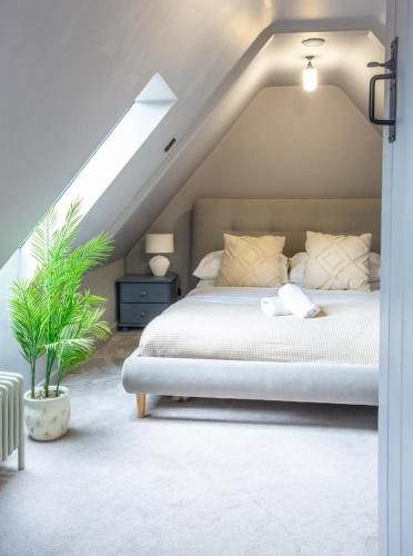 a bedroom with a white bed in a attic at Cotswolds Cottage with Hot tub in Leafield