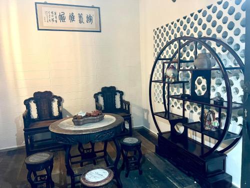 a room with a table and stools and a shelf at A Borneo Homestay in Johor Bahru