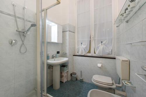 a white bathroom with a toilet and a sink at Cuore di Genova in Genova