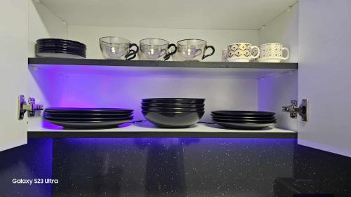 a shelf with black plates and cups on it at Luxury Apartments Black Diamond in Ši Selo