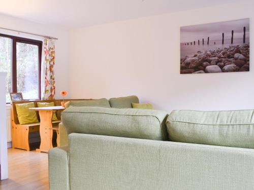 a living room with a couch and a table at Pine Marten Cottage in Ballachulish