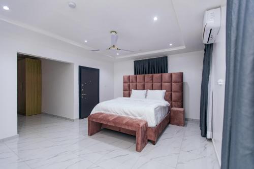 a bedroom with a large bed and a bench at BM Properties in Accra