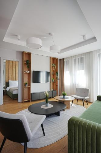 a living room with a green couch and a tv at Madera apartments in Čačak