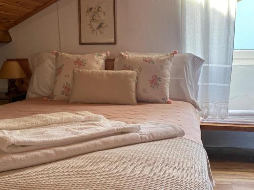 a bed with white sheets and pillows and a window at Charming Holiday House - House & Apartment in Biscoitos