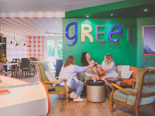 アヌシーにあるgreet hôtel Annecy Cran-Gevrier by Accorのレストランでワインを飲んでいる女性グループ
