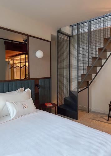 a bedroom with a white bed and a staircase at MÍMESIS 11 - Boutique Hotel in Como