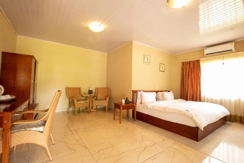 a bedroom with a bed and a table and chairs at Busua Beach Resort in Busua