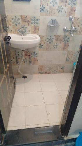 a bathroom with a sink and a white tiled floor at The Ajna Resident Rishikesh in Rishīkesh