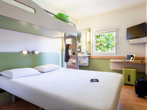 ein großes weißes Bett in einem Zimmer mit Fenster in der Unterkunft ibis budget Poitiers Nord Futuroscope in Chasseneuil-du-Poitou