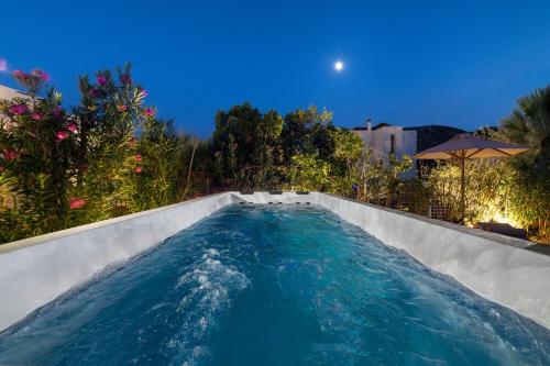 a swimming pool with blue water in a backyard at Le Soleil De Lindos - Luxury Villa with Swim Spa in Líndos