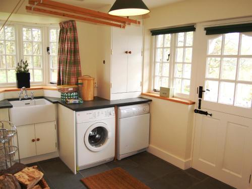una cocina con lavadora y fregadero en Overwater Lodge, en Bassenthwaite Lake