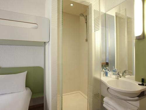 a bathroom with a sink and a mirror at ibis budget Tours Nord in Tours